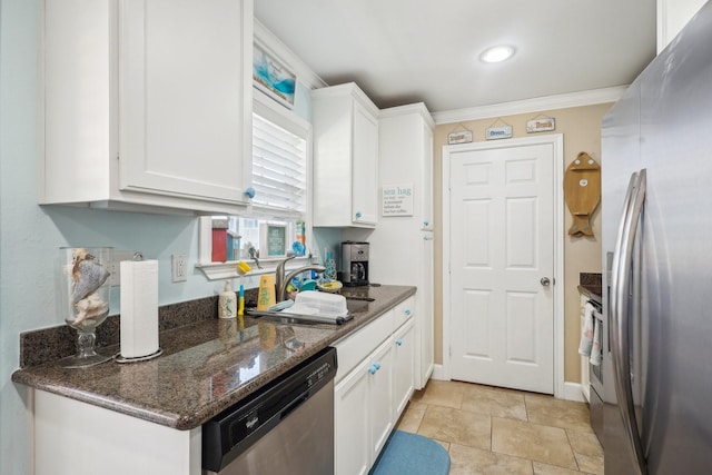 kitchen with appliances with stainless steel finishes, white cabinets, a sink, and crown molding