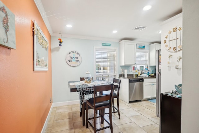 kitchen with visible vents, white cabinets, ornamental molding, stainless steel dishwasher, and dark countertops