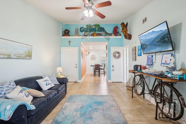 living area featuring baseboards, visible vents, a ceiling fan, and light tile patterned flooring