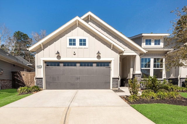 view of front of home with an attached garage, stone siding, board and batten siding, and concrete driveway