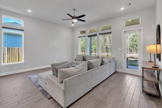 living area with baseboards, visible vents, wood finished floors, and recessed lighting