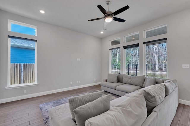 living area with ceiling fan, recessed lighting, wood finished floors, and baseboards