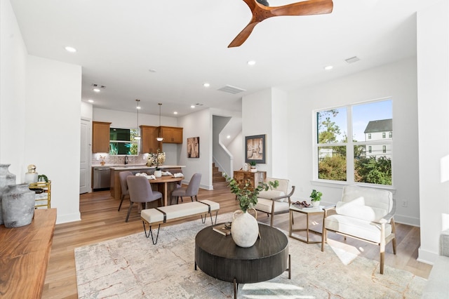 living room with recessed lighting, visible vents, baseboards, stairs, and light wood finished floors