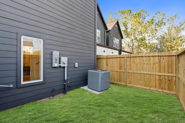 view of property exterior with a lawn, fence, and cooling unit