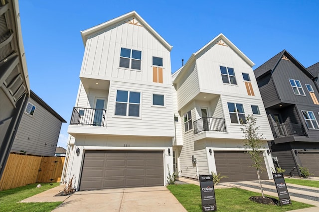 townhome / multi-family property featuring concrete driveway, board and batten siding, an attached garage, and fence