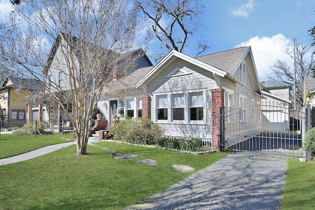 view of front facade with brick siding, fence, and a front lawn