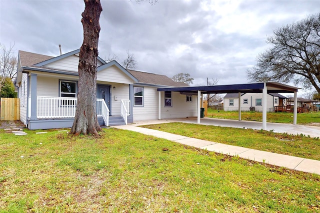 bungalow-style house with a front yard, fence, a carport, and covered porch