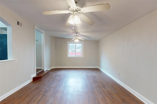 empty room featuring dark wood-type flooring, baseboards, and visible vents