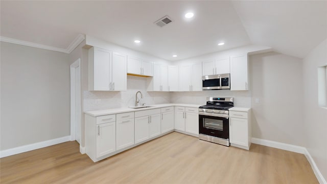 kitchen featuring light wood-type flooring, visible vents, a sink, stainless steel appliances, and light countertops