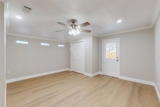 foyer entrance featuring visible vents, baseboards, light wood-style floors, and ornamental molding