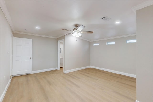 spare room featuring a ceiling fan, baseboards, visible vents, light wood-style flooring, and crown molding