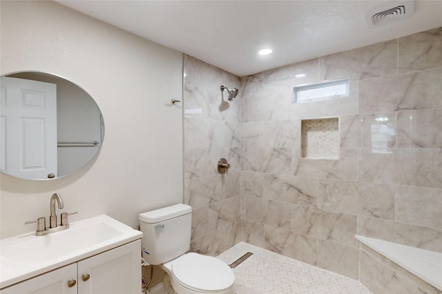 full bath featuring visible vents, toilet, vanity, and a tile shower