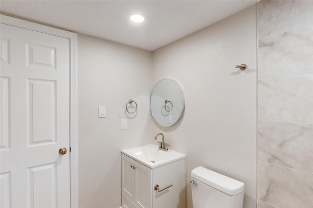 bathroom featuring recessed lighting, toilet, and vanity