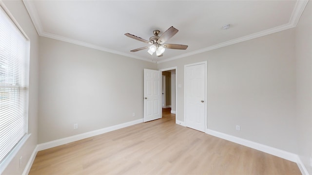 empty room with a ceiling fan, crown molding, light wood-style floors, and baseboards