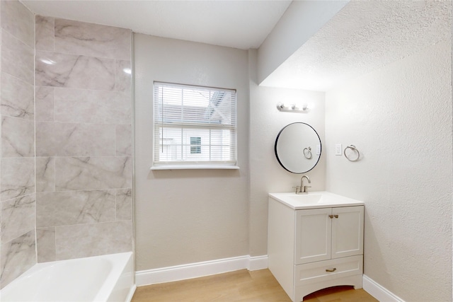 bathroom with shower / washtub combination, vanity, baseboards, and wood finished floors