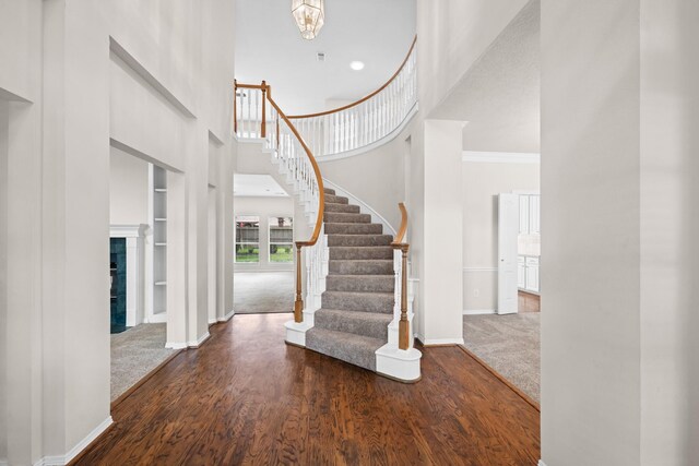 6923 Queensclub Dr, Houston, TX 77069 - carpeted foyer featuring a towering ceiling, wood finished floors, stairway, and crown molding