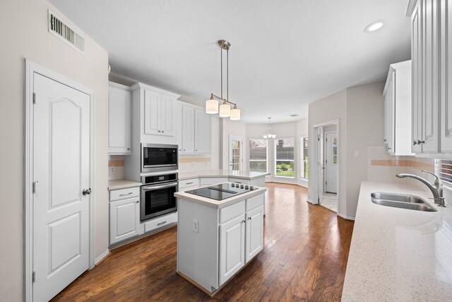 6923 Queensclub Dr, Houston, TX 77069 - kitchen with stainless steel appliances, white cabinets, a kitchen island, tasteful backsplash, and pendant lighting