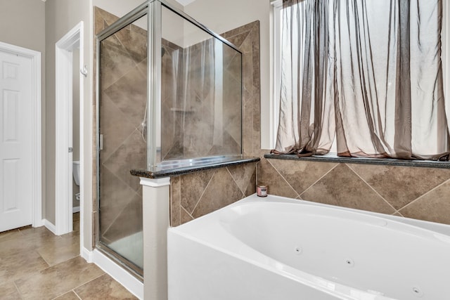 full bathroom featuring toilet, a jetted tub, and a shower stall