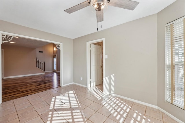 empty room with plenty of natural light, stairway, and light tile patterned floors