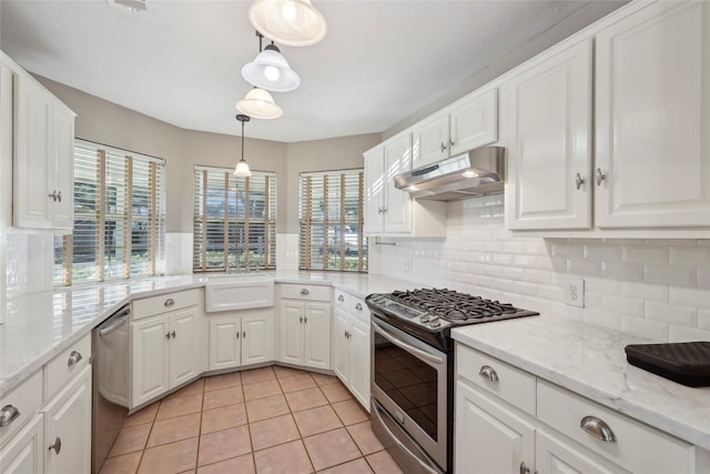 kitchen featuring stainless steel appliances, under cabinet range hood, white cabinetry, a sink, and light tile patterned flooring