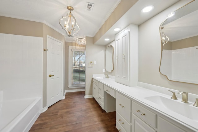 full bathroom featuring wood finished floors, a sink, visible vents, double vanity, and crown molding