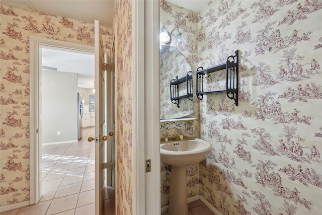 half bath with wallpapered walls, tile patterned flooring, and baseboards