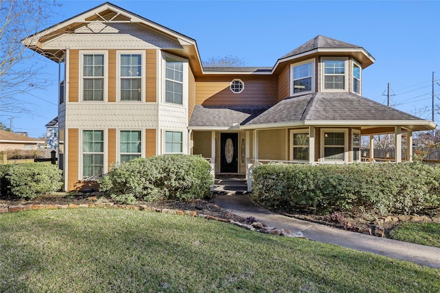 view of front of home with a front lawn and roof with shingles