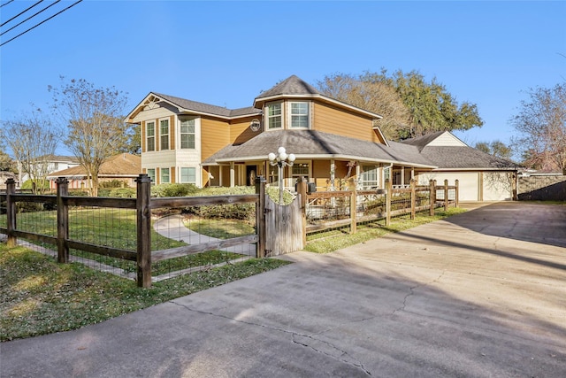 victorian house featuring a fenced front yard, covered porch, driveway, and a gate