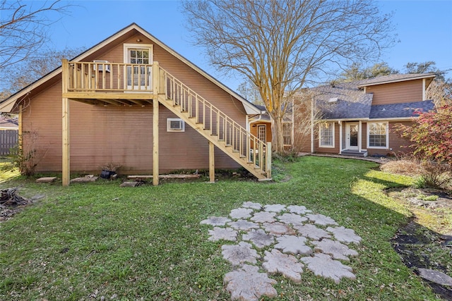 back of property with stairway and a lawn