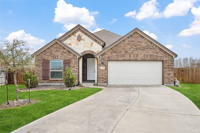 french country home featuring a garage, driveway, fence, a front lawn, and brick siding