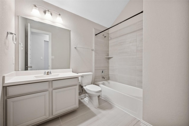 bathroom featuring lofted ceiling, a textured wall, toilet, vanity, and tub / shower combination