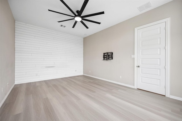 unfurnished room featuring light wood-style floors, visible vents, baseboards, and a ceiling fan