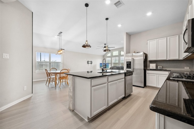 kitchen featuring dark countertops, visible vents, stainless steel appliances, and a sink