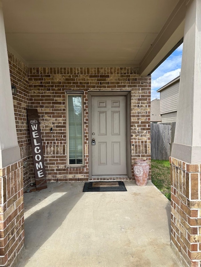 doorway to property with a patio area and brick siding