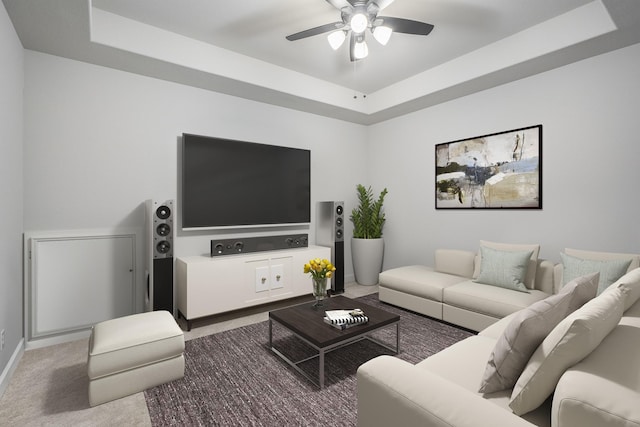 living room featuring a tray ceiling, carpet flooring, and ceiling fan