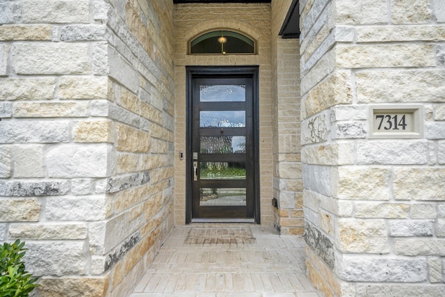 doorway to property with stone siding