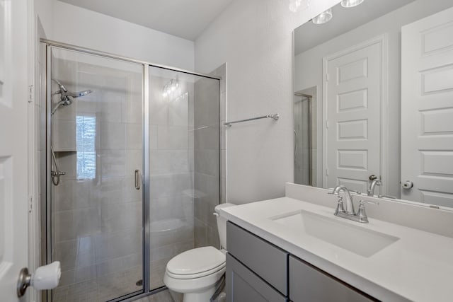 full bath featuring toilet, a shower stall, and vanity