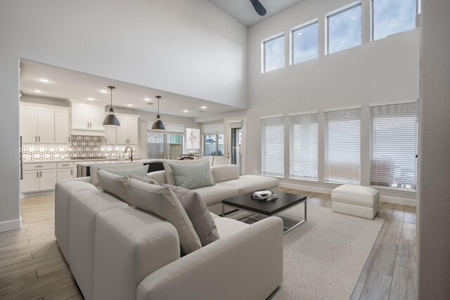 living room featuring light wood-style floors, baseboards, and recessed lighting