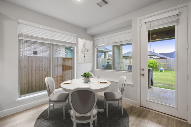 dining space with visible vents, light wood-style flooring, and baseboards