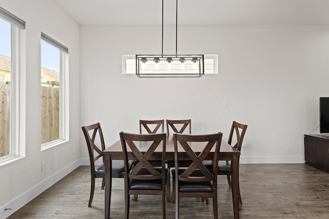 dining area with baseboards and wood finished floors