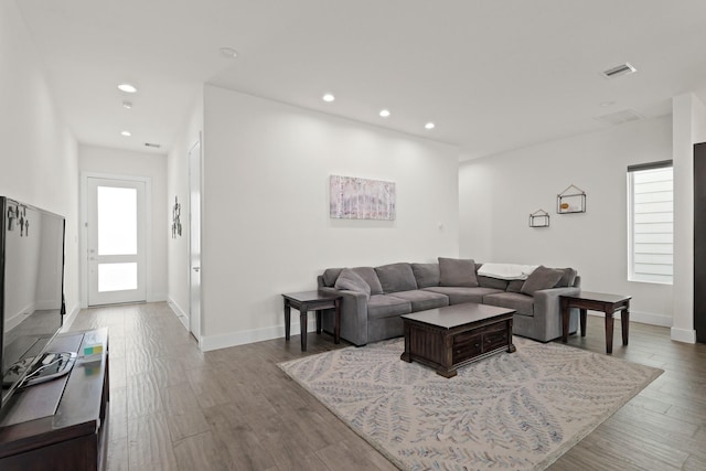 living room featuring a wealth of natural light, visible vents, and wood finished floors