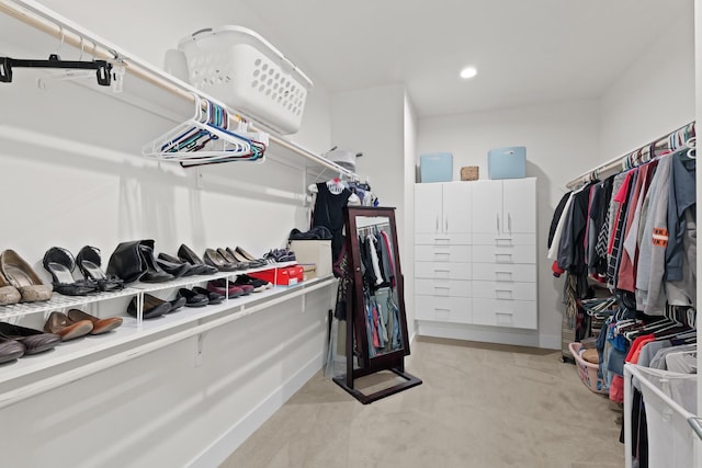 walk in closet with light carpet