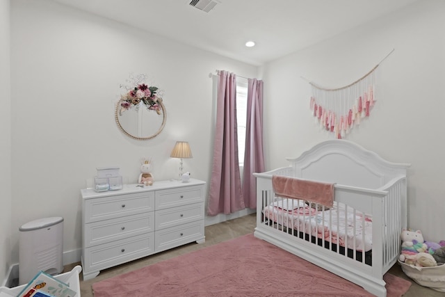 bedroom featuring visible vents and a crib