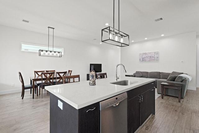 kitchen featuring a sink, visible vents, open floor plan, dishwasher, and an island with sink