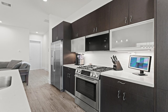 kitchen featuring stainless steel appliances, light wood finished floors, light countertops, and visible vents