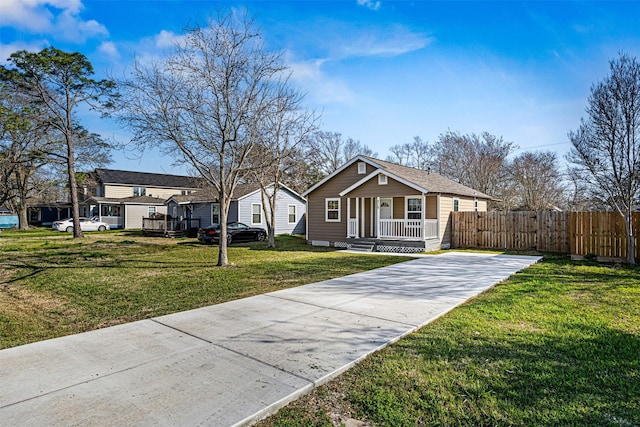 view of front of property featuring a porch, fence, and a front lawn