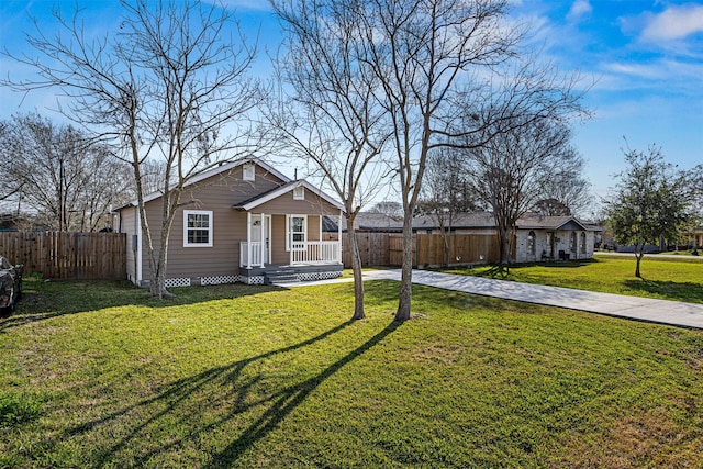 bungalow-style house featuring driveway, a porch, fence, and a front lawn