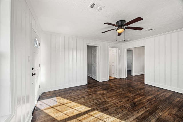 unfurnished room featuring a textured ceiling, visible vents, dark wood-type flooring, and ornamental molding