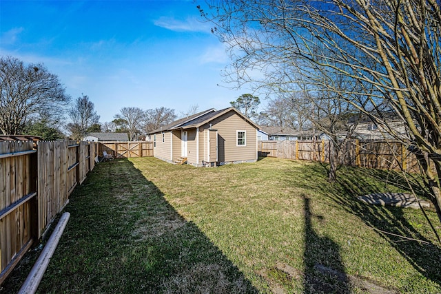 view of yard with a fenced backyard and an outbuilding