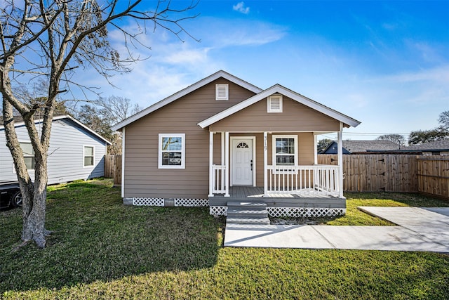 bungalow-style house featuring covered porch, a front yard, and fence